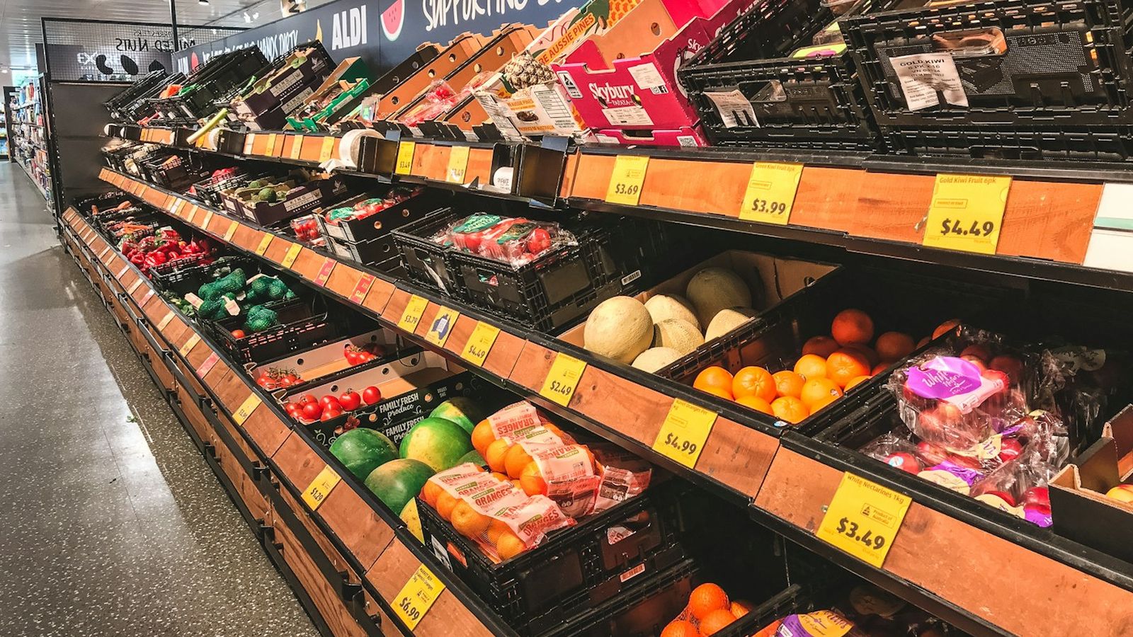 Fresh produce arranged on wooden supermarket shelving