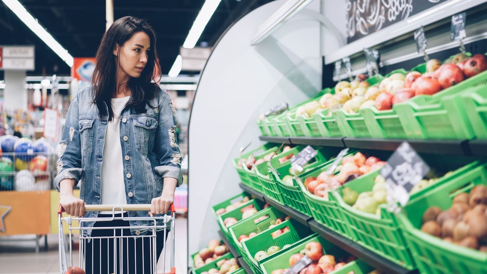 A shopper pushing a trolley through a supermarket